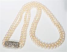 Zwei lange Akoya-Perlenketten mit hochwertiger Art-Déco Schmuckbrosche  als Verbindungselement beider Ketten.
