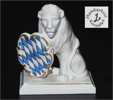 Sitzender Löwe mit blau-weißem Rautenschild