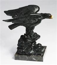Adler auf stilisiertem Felssockel.
